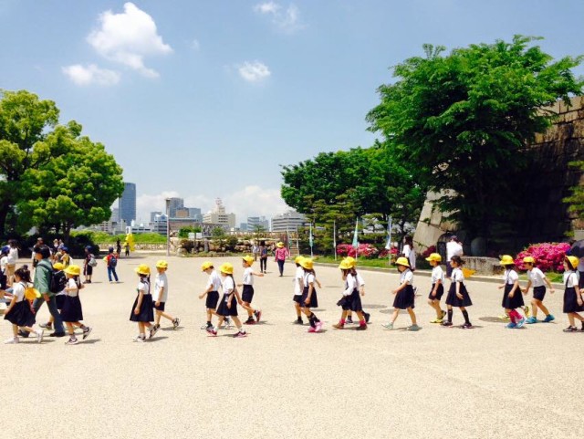 Orderly kids on a field trip at the Osaka Castle park.
